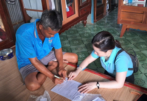 Cán bộ Trung tâm Phục vụ hành chính công xã Tân Hội hướng dẫn người dân làm thủ tục ủy quyền và mở thẻ ngân hàng để nhận tiền bảo trợ xã hội.