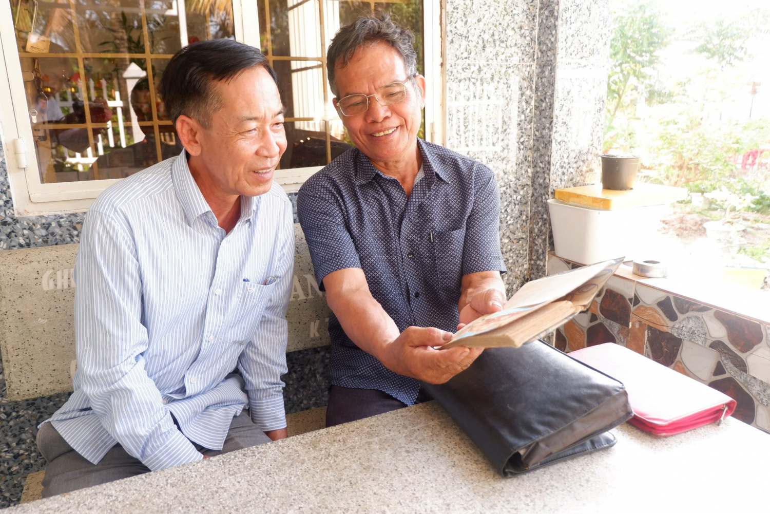 Cựu chiến binh Nguyễn Ngọc Chúc (bên phải) trò chuyện cùng ông Phạm Minh Đức - Bí thư Chi bộ, Trưởng ấp Tân Hòa A, xã Tân Hiệp B.