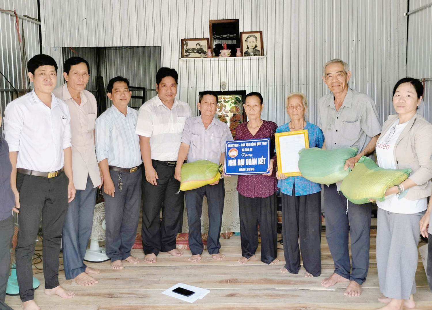 Ông Đặng Văn Tỷ (thứ hai, từ phải qua) trao quà cho hộ gia đình có hoàn cảnh khó khăn tại xã Tân An. Ảnh: Hoàng Mai
